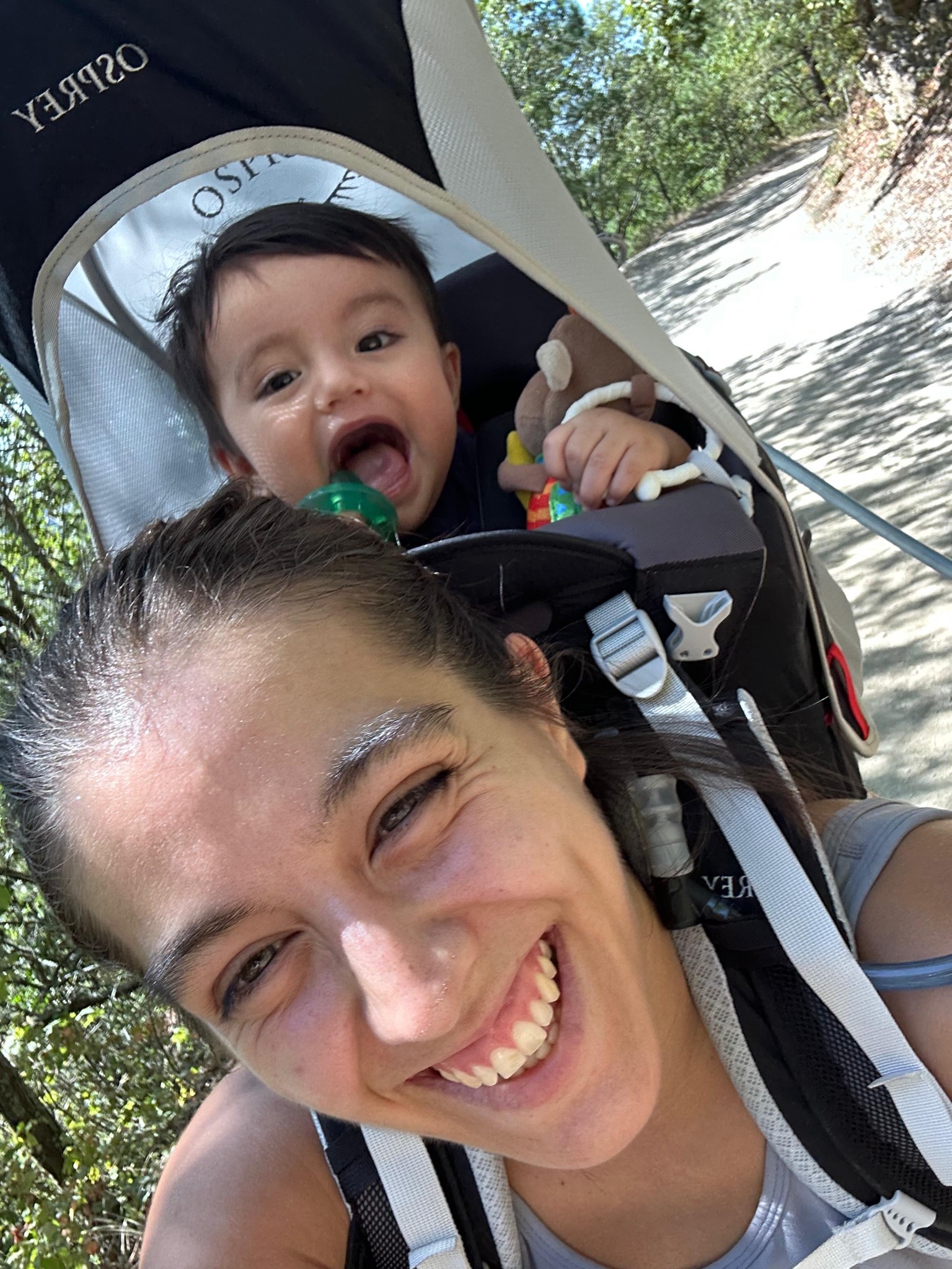 Ana cargando a su hijo Elian en una mochila portabebés durante un hike